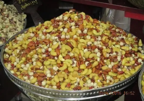 آجیل مخلوط تازه و با کیفیت شامل بادام هندی، بادام و فندق در سینی فلزی بزرگ، مناسب برای فروشگاه شیرینی پدیده شرق.