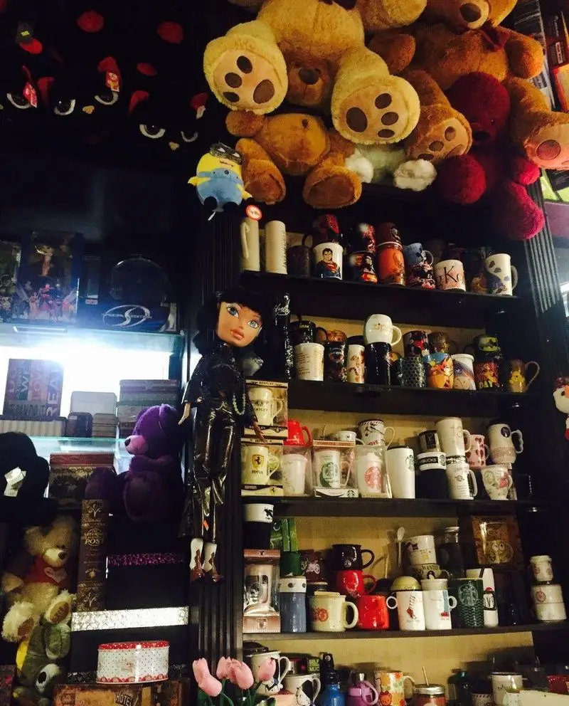 کافه خلبان: فضایی دلنشین و پر از جزئیات با خرس‌های آویزان، عروسک‌ها و قفسه‌های پر از ماگ‌های کلکسیونی و خاص.