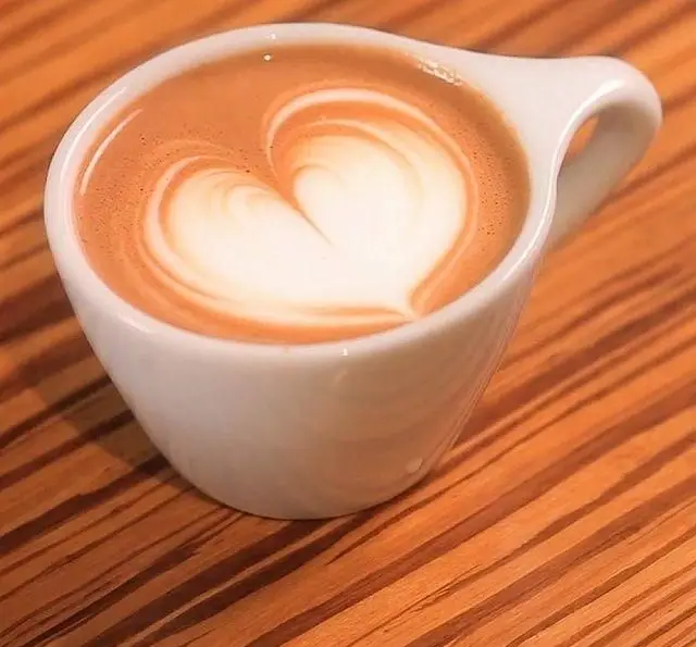 لذت یک فنجان لاته آرت زیبا با طرح قلب در کافه خلبان. قهوه‌ای باکیفیت و تازه برای لحظاتی دلپذیر و آرام در محیطی گرم و صمیمی.