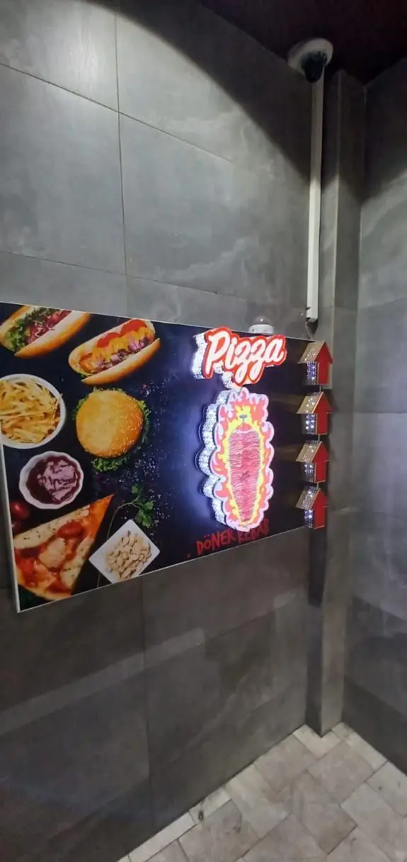 منوی غذایی رستوران شب‌های تهران شامل پیتزا، دونر کباب، هات‌داگ، برگر و سیب‌زمینی سرخ‌کرده با نورپردازی دکوراتیو.