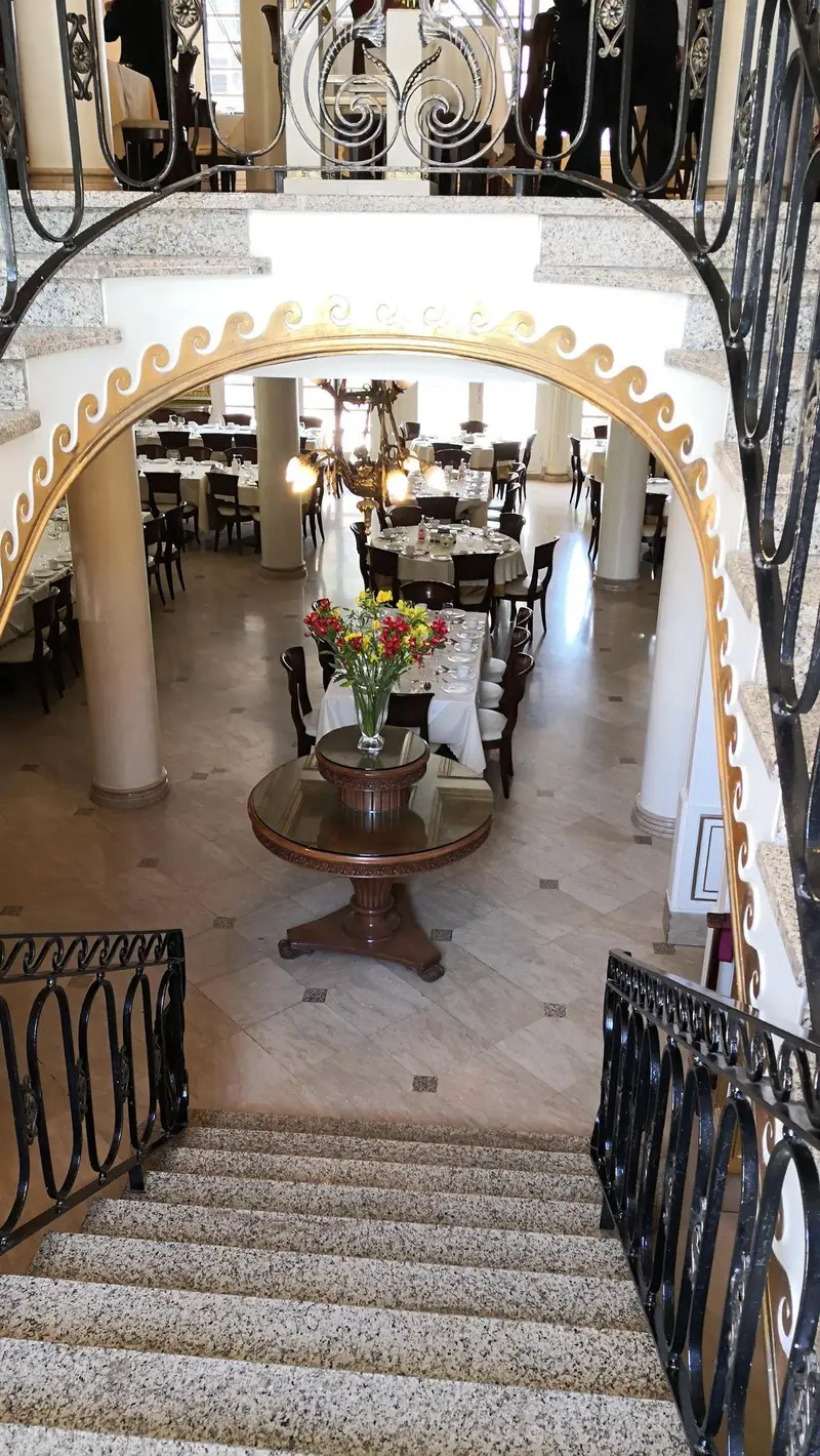 فضای داخلی لوکس رستوران نایب ساعی با پله‌های سنگی زیبا و نرده‌های تزئینی، و سالن غذاخوری شیک و دلباز با میزهای آماده پذیرایی.