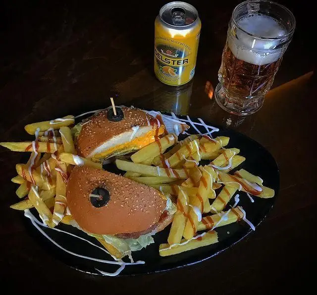 برگرهای لذیذ کافه رستوران ایتالیایی بلوکازا با سیب زمینی سرخ کرده فراوان و سس، در کنار نوشیدنی دلستر.