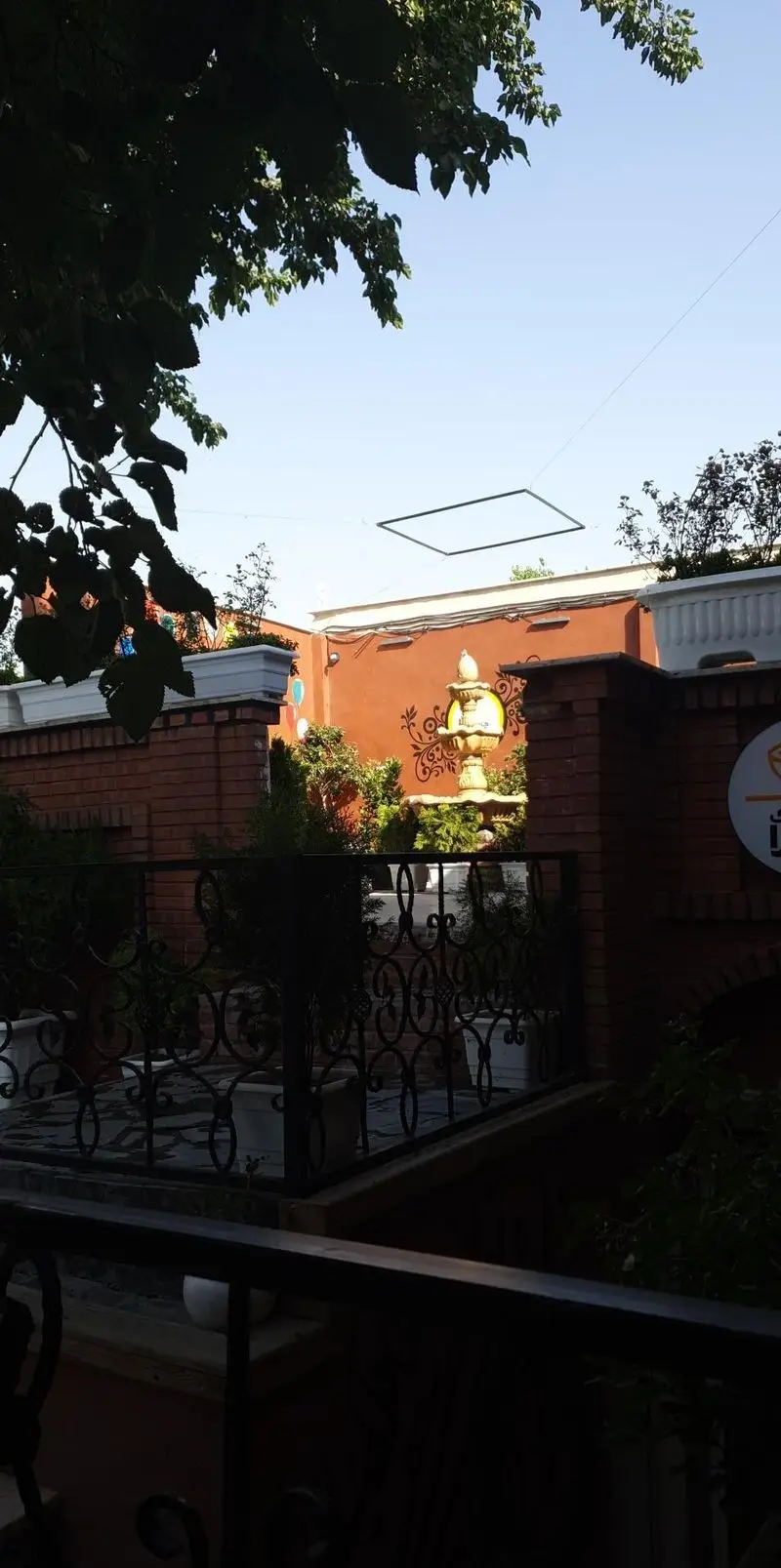 فضای باز دلنشین کافه بازی صحرا، حیاطی دنج با آبنما و نرده‌های فرفورژه، مکانی ایده‌آل برای بازی، استراحت و گذراندن وقت.