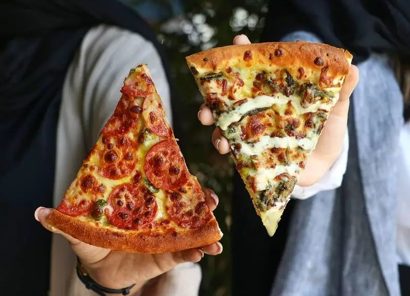 دو اسلایس پیتزای خوشمزه و پرطرفدار فست فود شیلا: یکی پپرونی تند و دیگری پیتزا سبزیجات با سس مخصوص و پنیر آب شده.