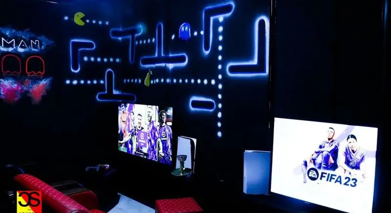 فضای مجهز گیم نت شبانه روزی سیسیلی شعبه ستارخان با دکور پک‌من نئونی، کنسول PS5 و بازی‌های FIFA 23.