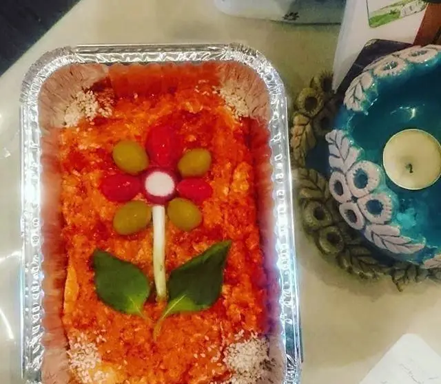 تزئین هنرمندانه غذای ایرانی در سینی، با گل سبزیجات و زیتون تازه، از رستوران دیزی شاپ. مناسب مراسم و مهمانی‌ها.