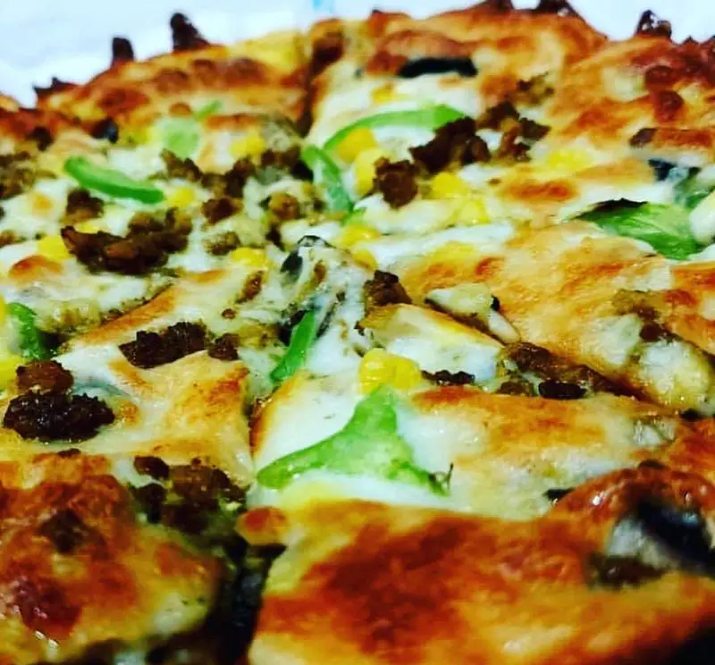 پیتزای ویژه و تازه فست فود ماموت: ترکیبی لذیذ از گوشت چرخ کرده، ذرت شیرین و فلفل دلمه سبز بر روی پنیر طلایی و آب شده.