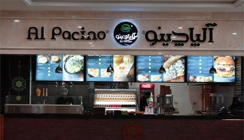 فست فود آلپاچینو: نمایی از پیشخوان و منوی دیجیتال با انواع ساندویچ، برگر و پاستا. محیطی شیک برای سفارش غذای سریع.