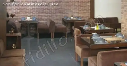 نمایی از محیط داخلی آرام و گرم رستوران تیلیت با دیوارهای آجری و مبلمان قهوه ای دنج، فضایی مناسب برای تجربه طعم لذیذ غذا.