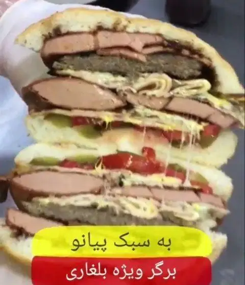 ساندویچ برگر ویژه بلغاری از فست فود پیانو، پر از کالباس، همبرگر، پنیر کشی، خیارشور و گوجه. غذایی عظیم و خوشمزه.