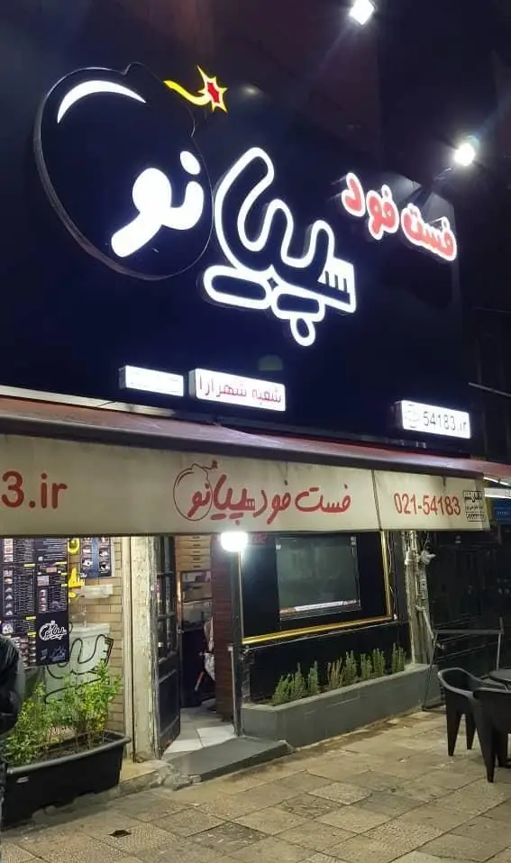 نمای شب از تابلوی نئون روشن فست فود پیانو، شعبه شهرآرا تهران، با لوگوی جذاب بمب، و اطلاعات تماس 021-54183 و 54183.ir.