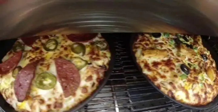 دو پیتزای لذیذ فست فود پیانو: پیتزا پپرونی و هالاپینو و پیتزا مرغ و زیتون در حال پخت در فر برای تجربه یک طعم بی‌نظیر.