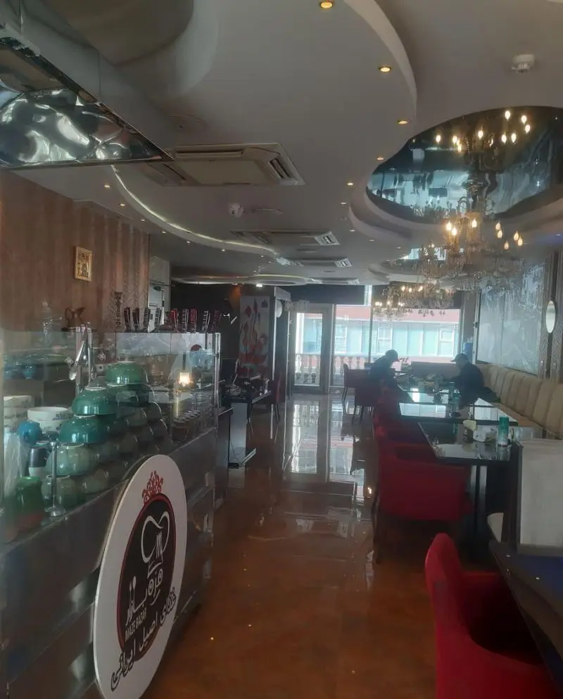 دکوراسیون داخلی لوکس رستوران تهران پاریس، با سقف زیبا، میز و صندلی‌های مدرن قرمز و ارائه دهنده بهترین غذاهای اصیل ایرانی.