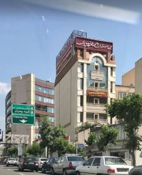 نمایی خارجی از رستوران تهران پاریس، یک رستوران بین المللی در تهران، با ساختمان شیک و مدرن در کنار خیابان و ترافیک.