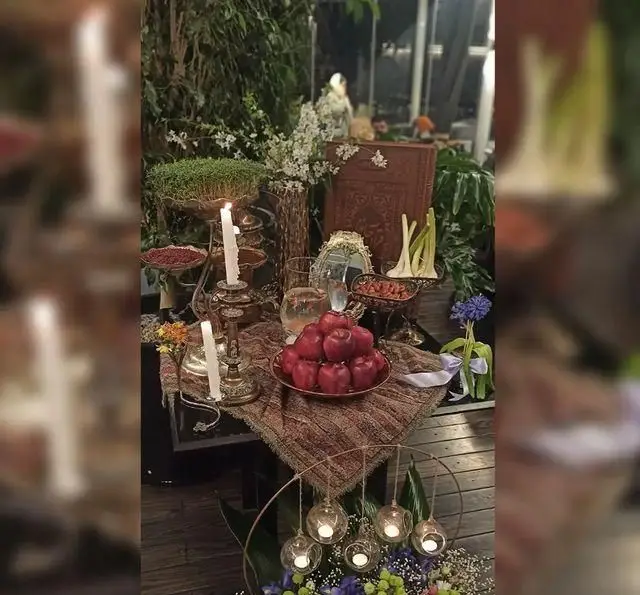 سفره هفت سین زیبا و سنتی نوروزی در رستوران 10forever، با شمع‌های روشن، سیب‌های قرمز و سبزه، فضایی دلنشین برای جشن سال نو ایرانی.