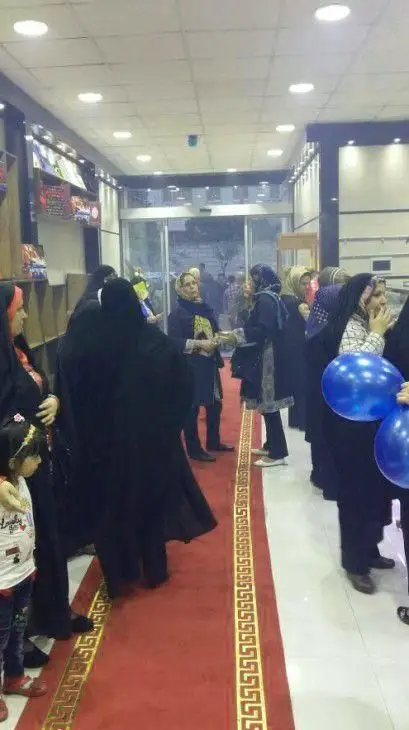 تصویری از مراسم افتتاحیه یا بازدید پرشور از شیرینی سرای آنتیک، با حضور پررنگ بانوان و مشتریان در فضای داخلی فروشگاه، برخی با بادکنک آبی در دست.