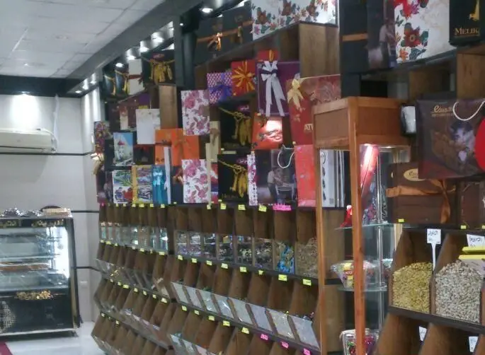فروشگاه شیرینی سرای آنتیک، با مجموعه‌ای از آجیل، خشکبار، شکلات‌های متنوع و بسته‌بندی‌های جذاب برای هدیه و کادو
