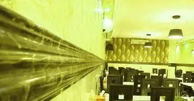 فضای داخلی رستوران ایرانی نشاط با چیدمان مرتب میز و صندلی‌ها و دکوراسیون گرم و دلنشین، آماده پذیرایی از میهمانان.