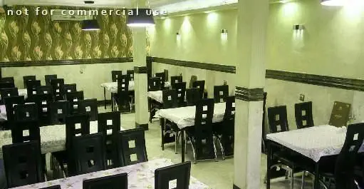 سالن غذاخوری رستوران ایرانی نشاط، با میز و صندلی‌های مشکی و رومیزی‌های سفید، آماده پذیرایی از مشتریان با محیطی دلنشین و دکوراسیون سنتی.