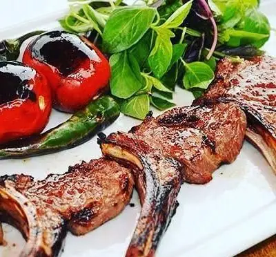 کباب دنده گوسفندی (شیشلیک) خوشمزه کافه رستوران بلوط، با گوجه و فلفل کبابی و سبزی تازه. طعمی اصیل و فراموش‌نشدنی.