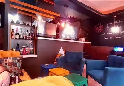 کافه جاده هشتاد، فضایی دلنشین و آرام با مبلمان راحتی آبی، میز بار کامل و نورپردازی مدرن برای سرو انواع نوشیدنی‌ها.