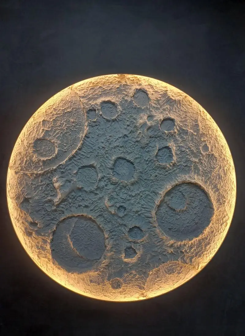 دکوراسیون منحصر به فرد کافه سِمِنت: چراغ دیواری طرح ماه با بافت برجسته سیمانی و نورپردازی گرم و محیطی.