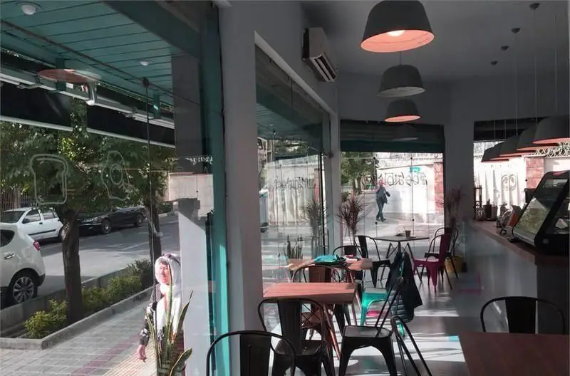 تصویری از فضای داخلی دلنشین و مدرن کافی شاپ بیت بیسترو، شامل میز و صندلی، نورپردازی زیبا و پنجره‌های رو به خیابان.