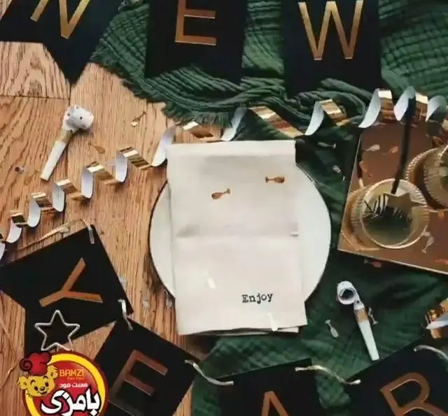 دکوراسیون شیک جشن سال نو فست فود بامزی ازگل با بنر طلایی، ربان، بوق و چیدمان رومیزی "Enjoy" برای مهمانی.