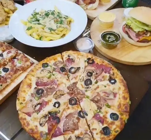 میز رنگین فست فود بامزی ازگل با پیتزای پرمحتوا، پاستای خامه‌ای و برگرهای لذیذ. تجربه بهترین فست فود در ازگل.