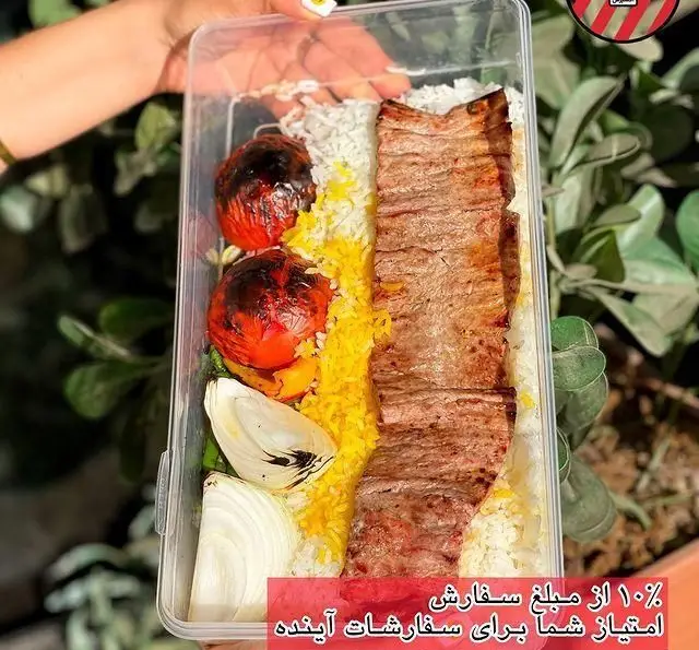 کبابچی اکسپرس اکباتان: یک پرس کباب لذیذ با برنج زعفرانی، گوجه کبابی و پیاز تازه در ظرف شفاف، آماده ارسال.