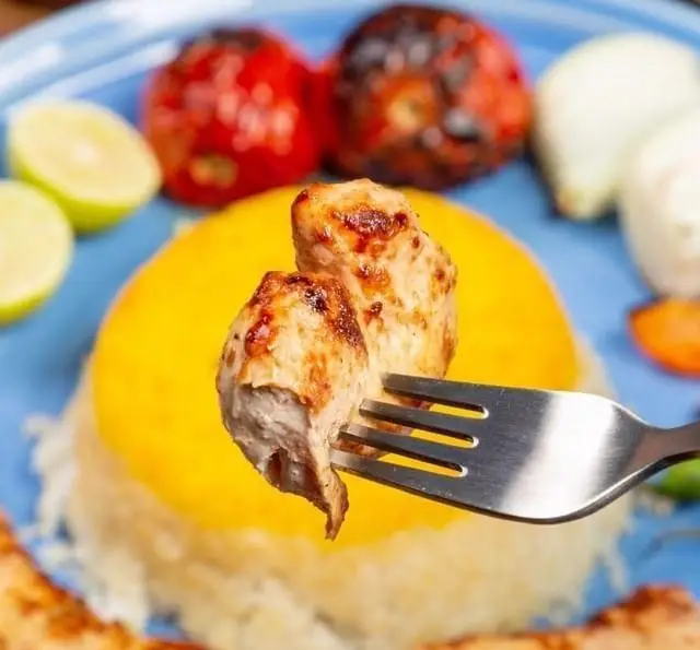 کباب مرغ چنجه آبدار کبابچی اکسپرس اکباتان روی چنگال، همراه برنج قالبی زعفرانی، گوجه کبابی و لیمو، بهترین غذای ایرانی