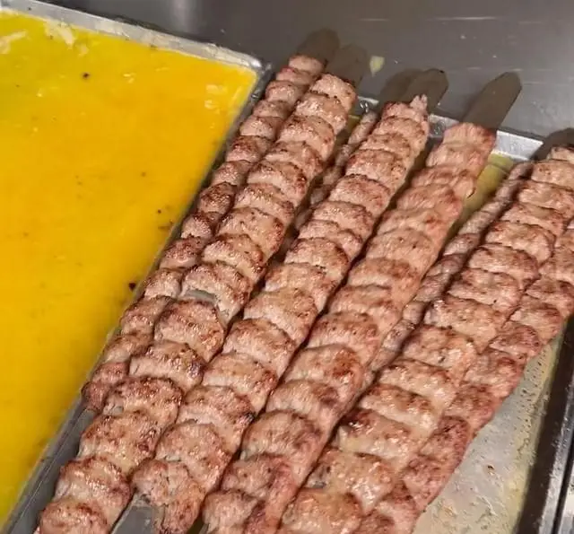 سیخ‌های کباب کوبیده تازه و پخته شده در کبابچی اکسپرس شعبه اکباتان، آماده سرو به همراه روغن یا کره.