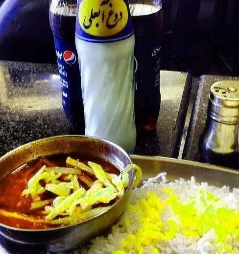 غذای ایرانی کامل و تازه شامل خورشت سیب زمینی، پلو زعفرانی و دوغ آبعلی در کافه رستوران عمو هوشنگ، محیطی دنج و دلنشین.