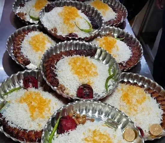 چلوکباب کوبیده و برگ ممتاز رستوران برکتی، برنج زعفرانی معطر، گوجه کبابی و فلفل سبز تازه، یک وعده غذای اصیل ایرانی.