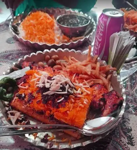 رستوران برکتی: میز غذای کامل و لذیذ ایرانی شامل زرشک پلو با مرغ، جوجه کباب، سیب زمینی سرخ شده و انواع مخلفات تازه.