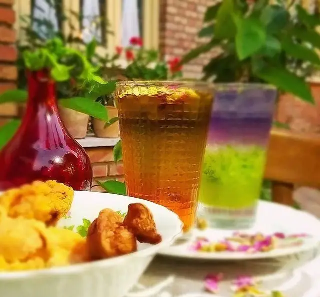 نوشیدنی‌های خنک و دسرهای سنتی ایرانی در فضای دلنشین کافه عمارت نیلی، مناسب برای عصرانه‌ای آرام و خاطره‌انگیز.