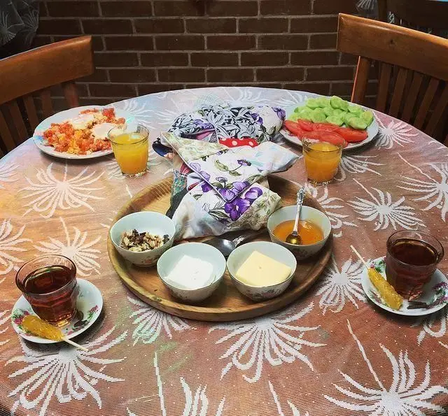 میز صبحانه دلنشین و کامل در کافه عمارت نیلی: املت، سبزیجات تازه، چای، آبمیوه، پنیر، کره، عسل و مغزیجات. تجربه‌ای لذت‌بخش در کافه‌ای زیبا.