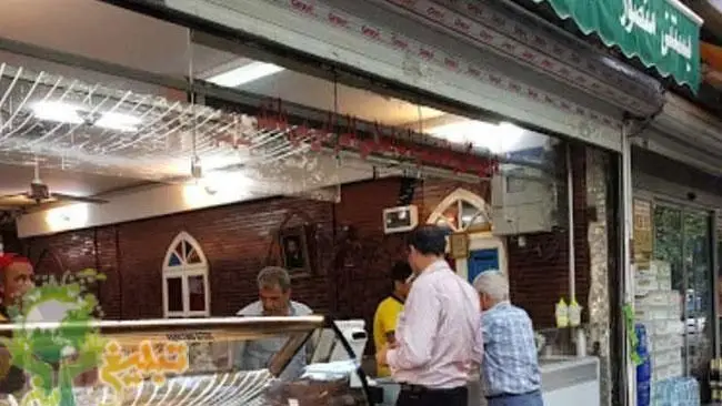 نمای داخلی مغازه بستنی منصور، یک کسب و کار محبوب که بستنی و دسرهای سنتی را به مشتریان مشتاق در فضایی دلنشین ارائه می‌دهد.