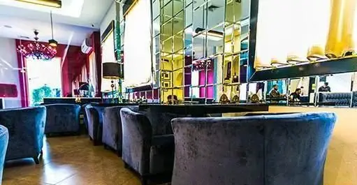 فضای داخلی شیک کافه رستوران کازابلانکا با مبلمان راحتی آبی، دیوارهای آینه‌ای و دکوری مدرن، محیطی آرامش‌بخش برای مشتریان.