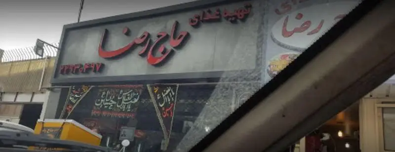 تصویر نمای بیرونی رستوران و تهیه غذای حاج رضا با تابلوی قرمز رنگ و بنرهای عزاداری، همراه با شماره تلفن ۴۴۴۲۴۵۲۷