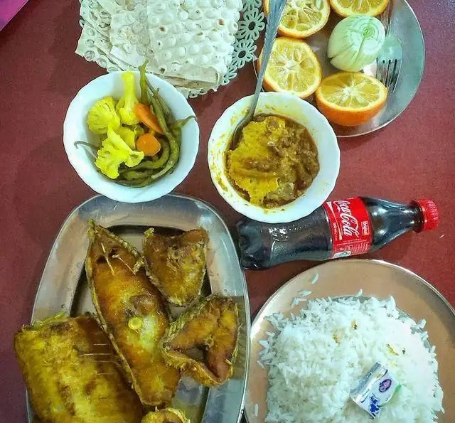 وعده غذایی کامل در رستوران لاکان: ماهی سرخ‌شده، پلو، خورشت، ترشیجات متنوع، نان و مرکبات تازه. لذت غذای اصیل ایرانی.