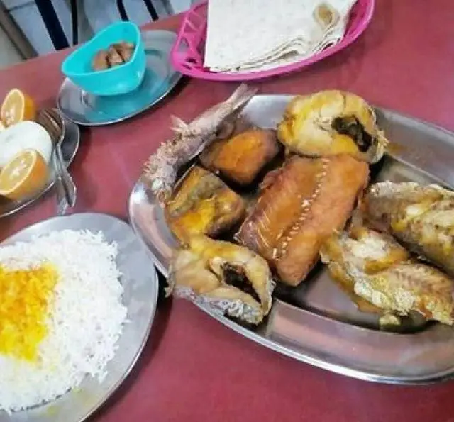 سفره‌ای لذیذ از انواع ماهی تازه و غذای دریایی رستوران لاکان به همراه برنج زعفرانی، نان تازه و مخلفات؛ تجربه‌ای خوشمزه.