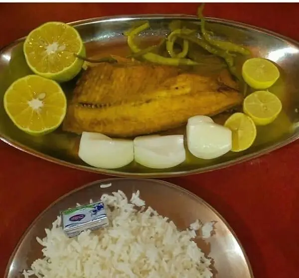 غذای اصیل ایرانی: ماهی سرخ شده تازه با لیمو، پیاز و فلفل ترشی، همراه پلو سفید و کره. لذت طعم لذیذ در رستوران لاکان رشت.