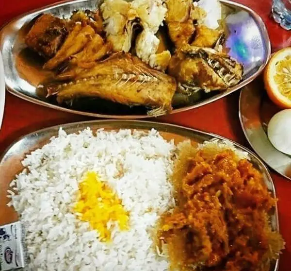 غذای اصیل ایرانی در رستوران لاکان: ماهی سرخ شده، برنج زعفرانی و خورشت مخصوص. طعم لذیذ و تجربه‌ای بی‌نظیر.