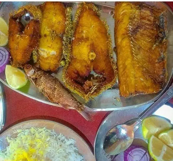 ماهی سرخ شده لذیذ با برنج از رستوران لاکان. تجربه غذای دریایی تازه و خوشمزه، همراه با لیمو و پیاز، یک وعده کامل و اشتهاآور.