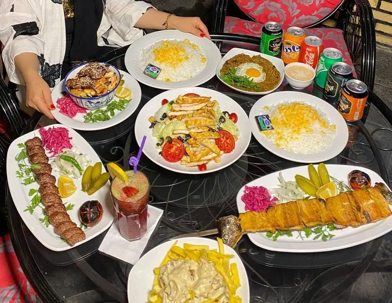 میز باشکوهی از غذاهای اصیل ایرانی در کافه رستوران کندو: چلوکباب، ماهی کباب، سالاد سزار مرغ، خورشت و نوشیدنی‌های خنک و گوارا.