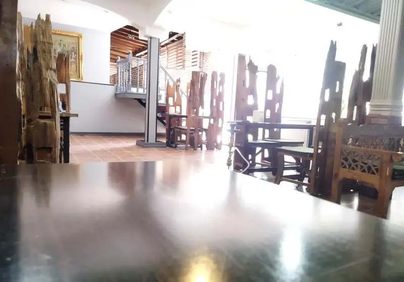 فضای داخلی دلنشین کافه رستوران کندو با میز و صندلی‌های چوبی با طرحی خاص، پلکان زیبا و آثار هنری. محیطی گرم و منحصربه‌فرد.