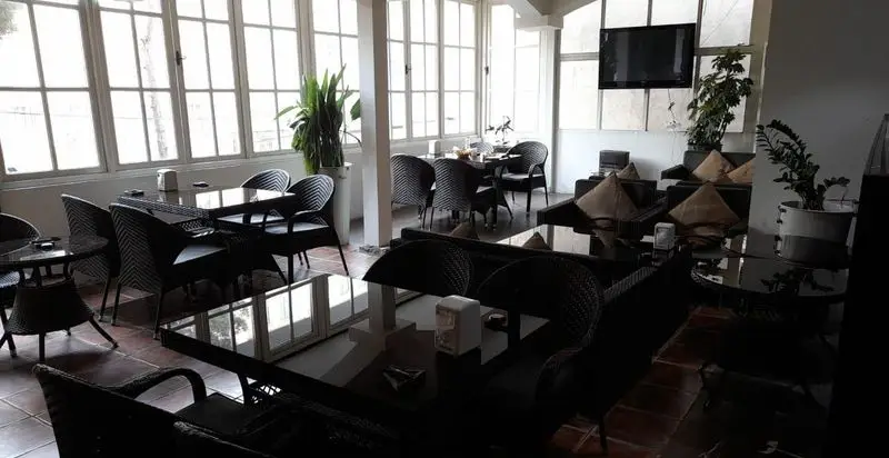 نمایی از دکوراسیون داخلی کافه رستوران کندو، با چیدمان متنوع میز و صندلی، مبلمان راحتی و نور طبیعی دلپذیر.