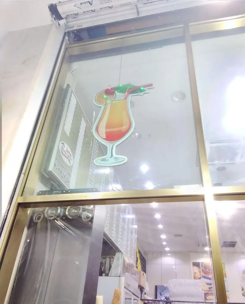 نمای داخلی و دکوراسیون شیک بستنی فروشی و کافه بستنی ونیز، با تصویر آبمیوه و منوی فروشگاه، محیطی دلنشین برای مشتریان.