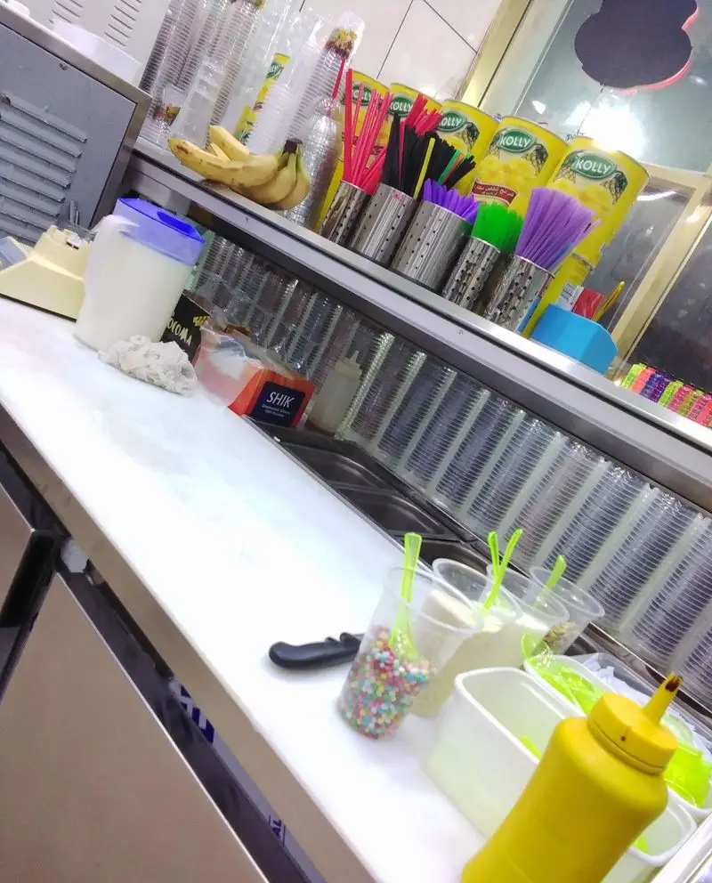 پیشخوان پرکار بستنی ونیز با موز، نی‌های رنگی، سیروپ KOLLY، لیوان، اسموتی‌های تازه، میلک‌شیک و مواد اولیه خوشمزه. آماده سرو.